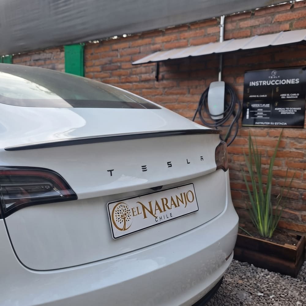 Auto eléctrico estacionado junto al cargador del hotel